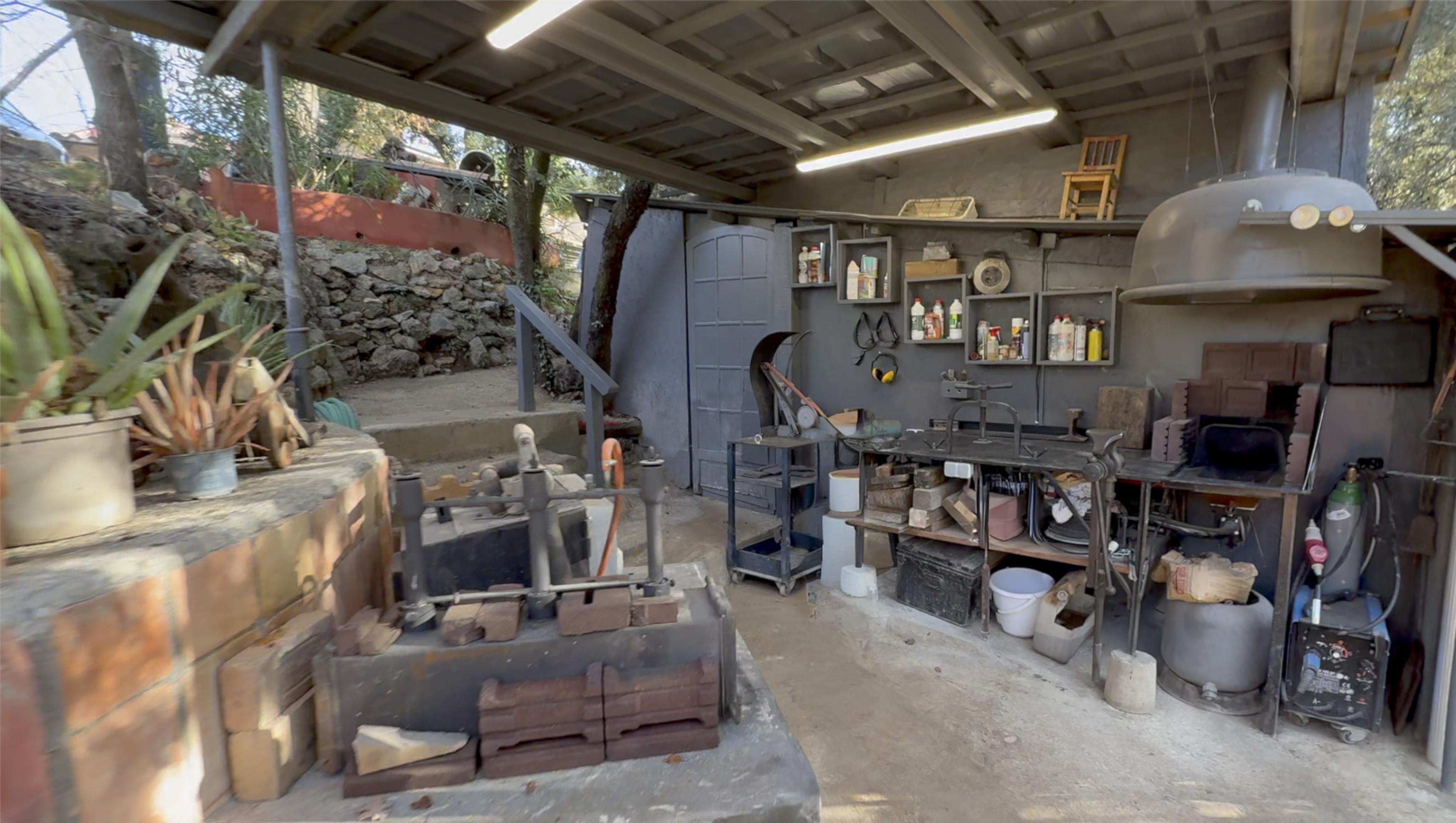 Forge, enclume et poste de meulage avec vue sur les collines